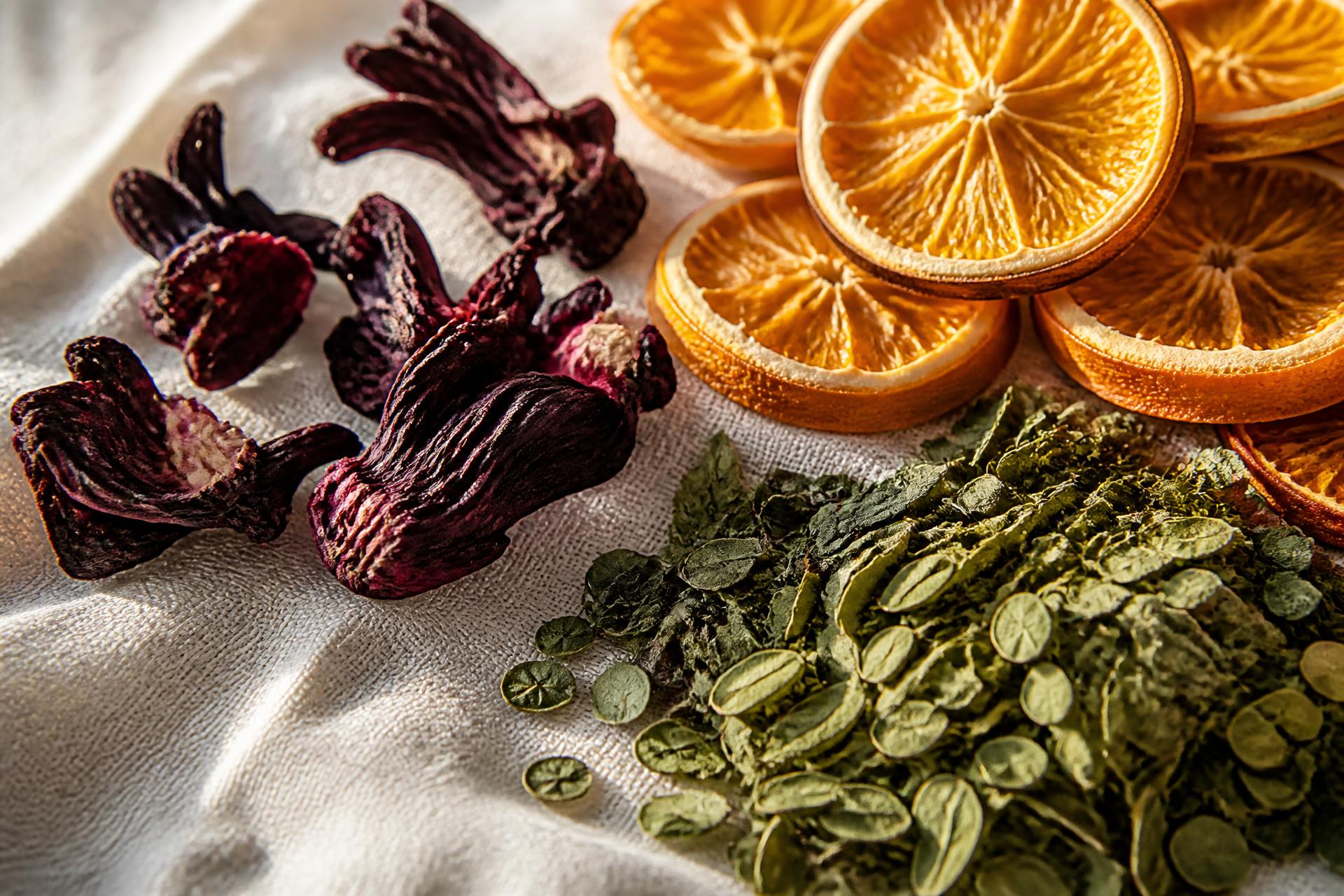 Dehydrated hibiscus, orange slices and moringa on ivory linen